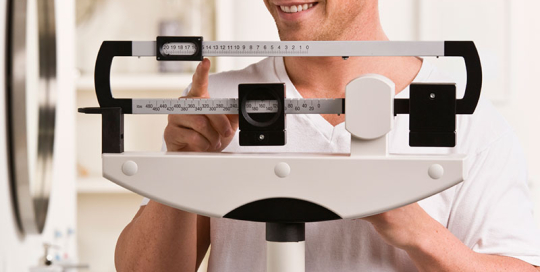 Man weighing himself on a scale